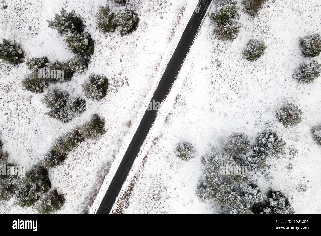 Luftaufnahme der leeren schneebedeckten Straße im Winterwald. Hochwertige Fotos. Stockfoto