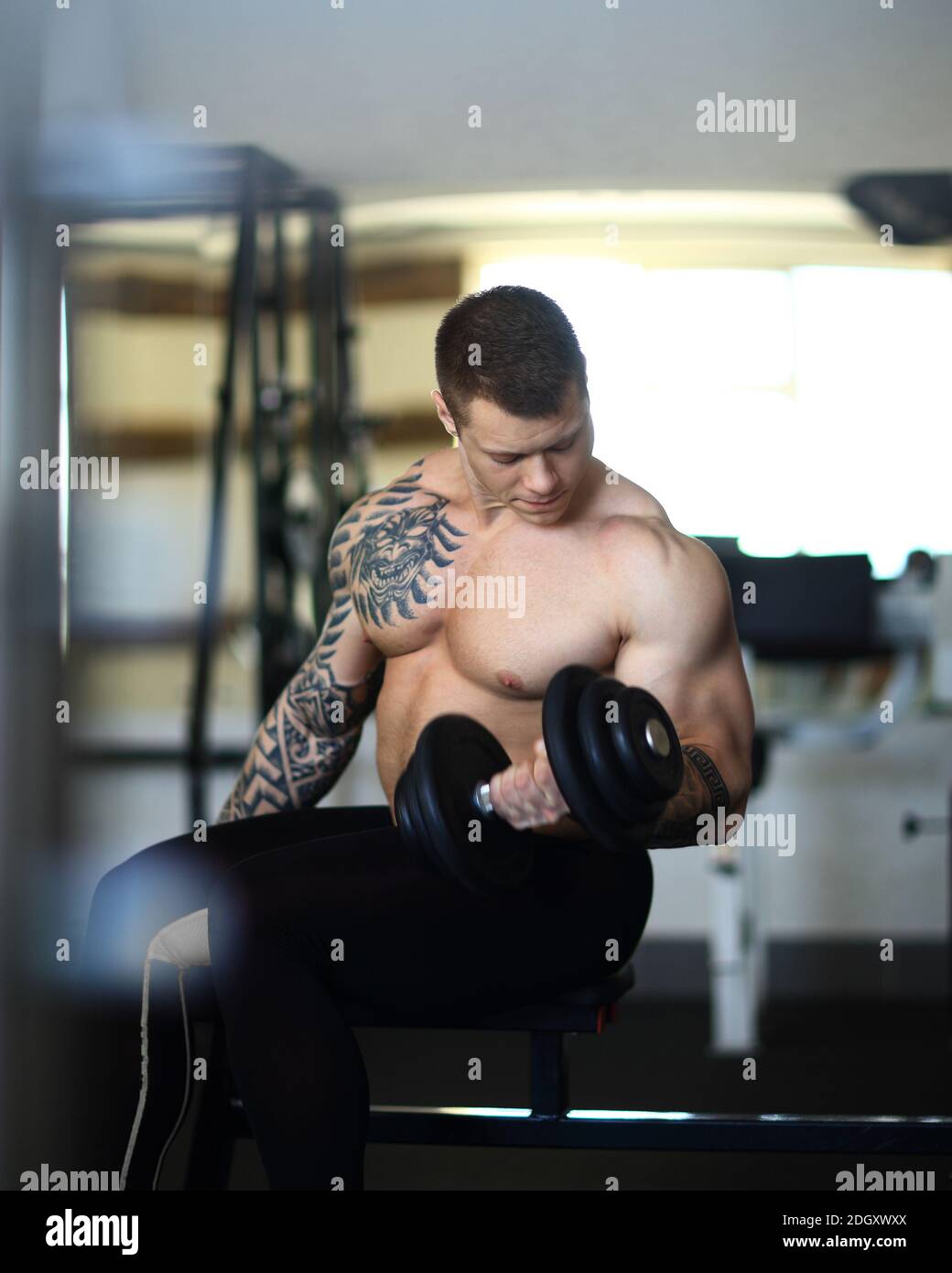 Bodybuilder Durchführung von Übungen in Hanteln im Fitnessstudio. Stockfoto