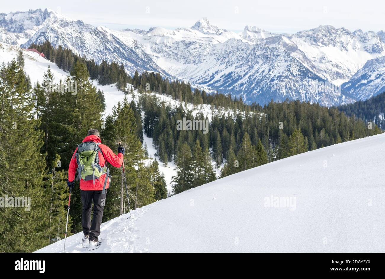 Senior Mann ist Schneeschuhwandern in alpinen Schnee Winter Berge. Allgau, Bayern, Deutschland. Stockfoto