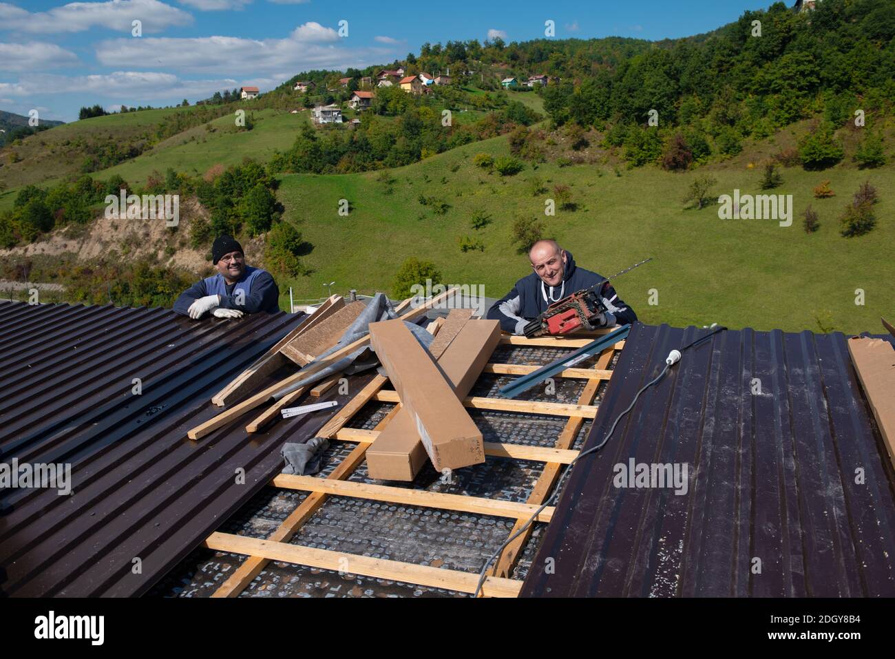 Bauarbeiter, der ein neues Dach installiert Stockfoto