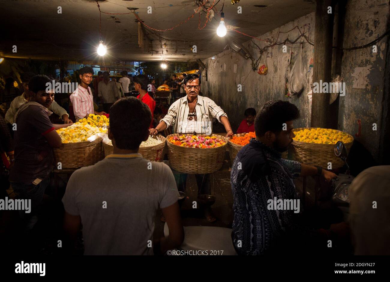 Ein Blumenhändler sitzt an seinem Stand auf dem Dadar Flower Market in Mumbai Stockfoto