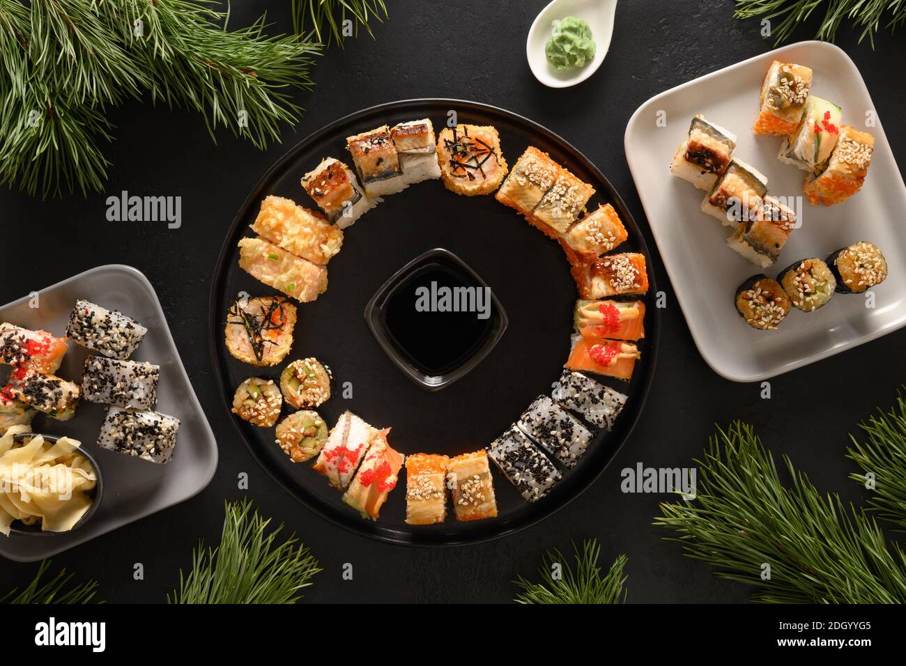 Weihnachten Brunch mit Sushi als Kranz auf schwarzem Hintergrund gesetzt. Blick von oben. Flache Lay-Optik. Weihnachten oder Silvester festliche Party. Stockfoto
