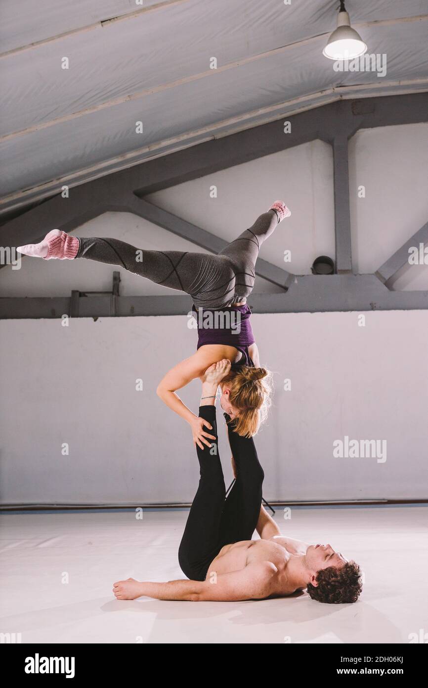 Themensport und ein gesunder Lebensstil. Akrobatik und acroyoga. Junge sportliche Paar üben acroyoga Handstand. Männlich und weiblich Stockfoto