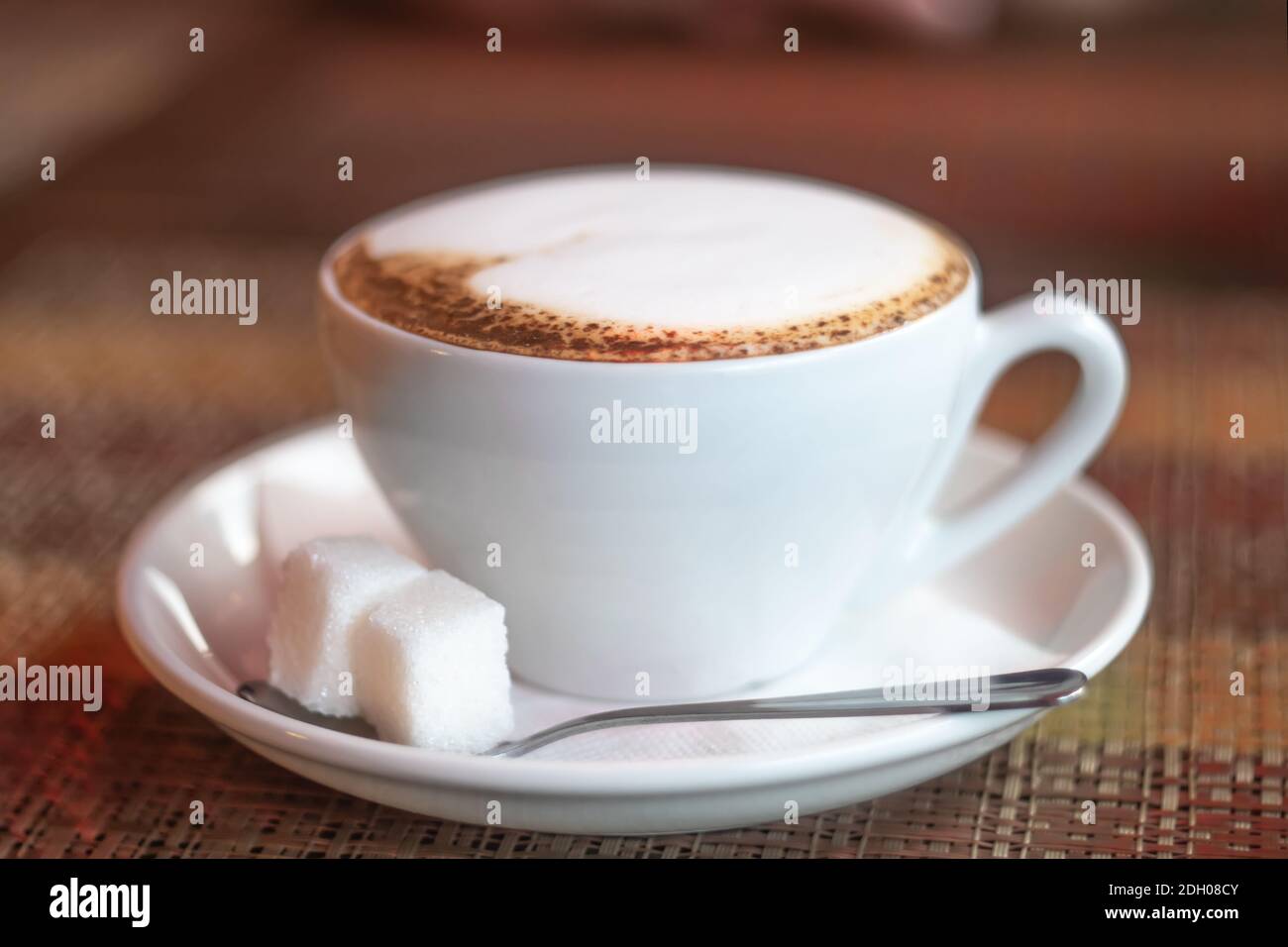 Tasse Kaffee auf einem Holztisch mit zwei Stücken Von Shugar Stockfoto