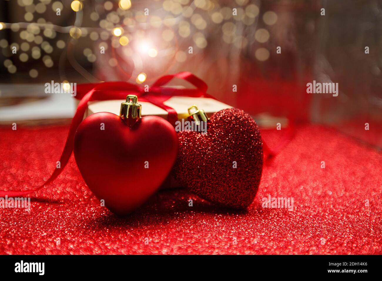 Rote Herzen auf dem Hintergrund des Geschenks. Roter Hintergrund, Valentinstag Konzept Stockfoto