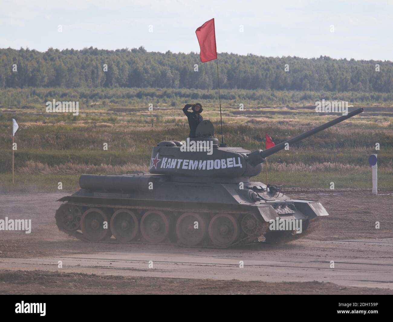 Der Panzerkommandant T-34 begrüßt das Publikum während des Wettbewerbs.am Tag der Eröffnung der Internationalen Armeespiele "ARMY-2020" fanden Panzerbesatzungen auf den glorreichen sowjetischen T-34-Panzern statt, den besten Panzern des Zweiten Weltkriegs. Im Jahr 2020 nahmen die Militärabteilungen von 19 Staaten, darunter Weißrussland, Kasachstan, China und Russland, am Wettbewerb Tank Biathlon Teil, dessen Teams mehrere Gewinner und Preisträger des Wettbewerbs waren. Stockfoto