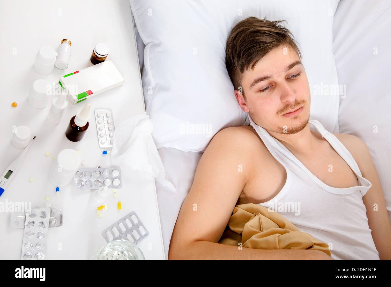 Trauriger und kranker junger Mann im Bett im Zu Hause Stockfoto