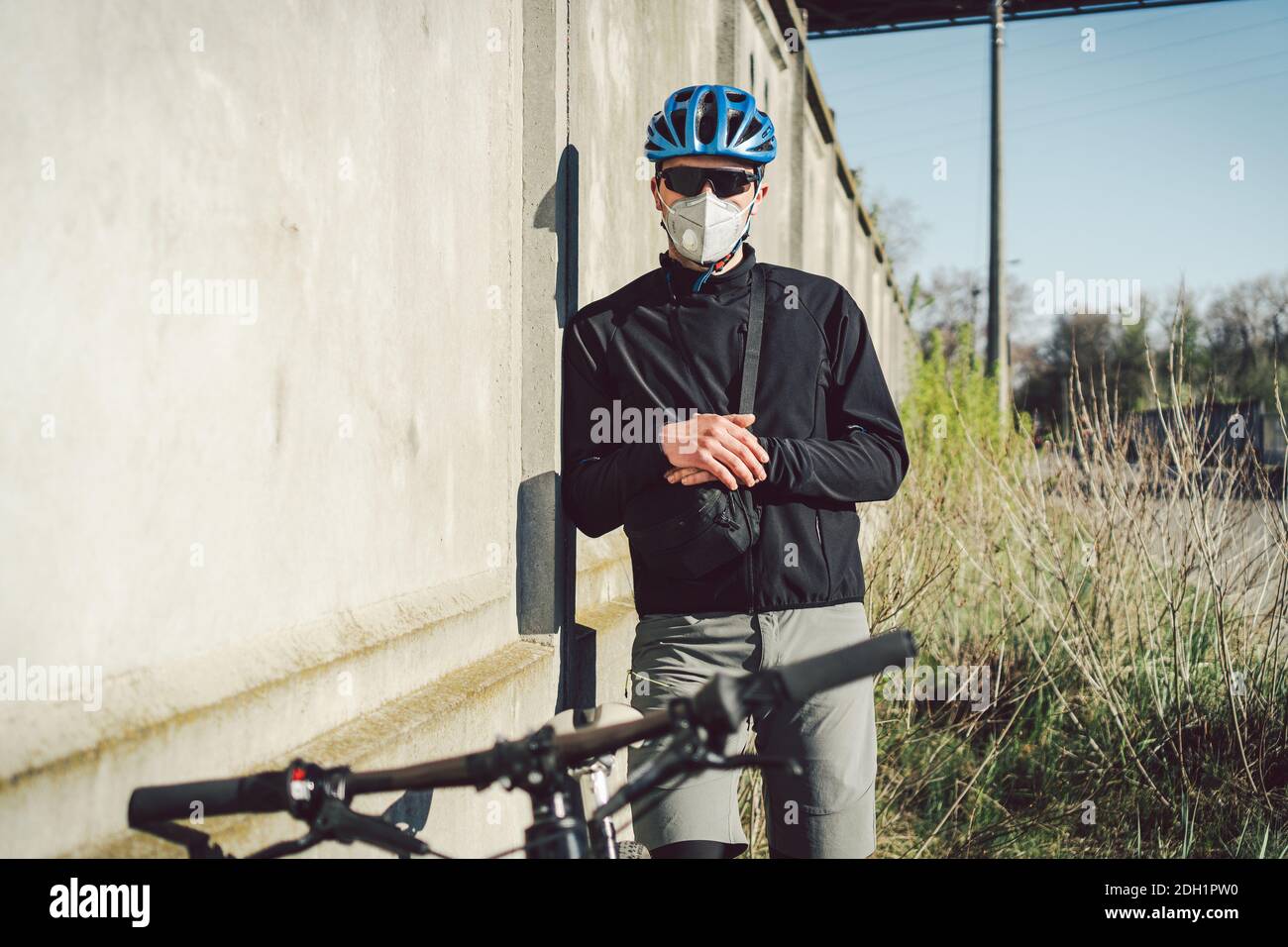 Radfahrer in Gesichtsmaske durch Smog in der Stadt. Fahrrad Kurier eine  Lieferung. Mann mit Covid 19 Coronavirus Maske. Radfahrer in  Stockfotografie - Alamy