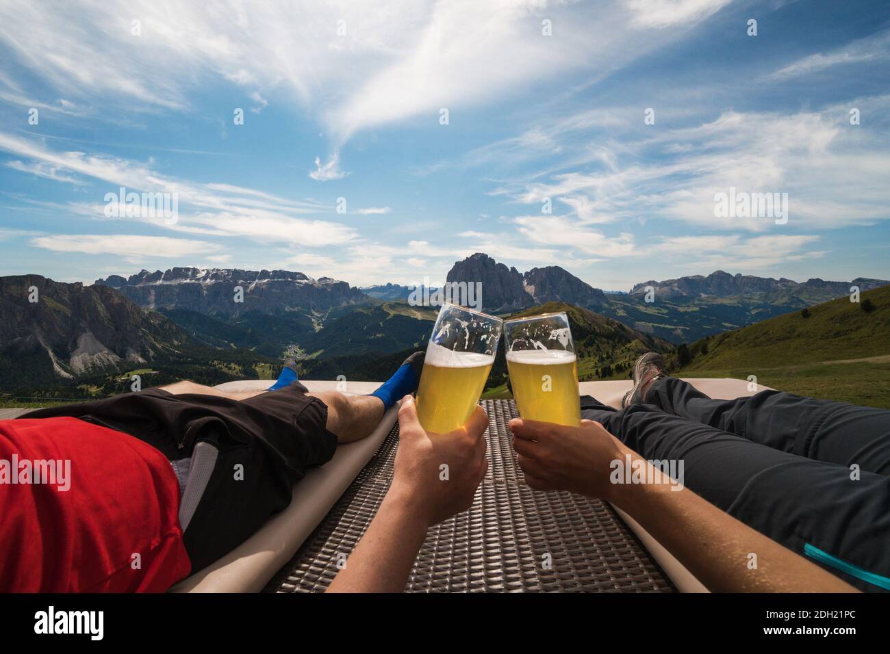 Nahaufnahme der Vorderansicht auf männlichen und weiblichen kaukasischen Händen halten Gläser Bier und Toasten, in der Mitte der Berge, schöne Naturlandschaft Stockfoto