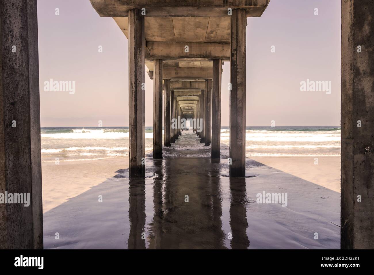 Blick auf EINEN Pier mit Wellen, die in die Struktur einstürzen Stockfoto