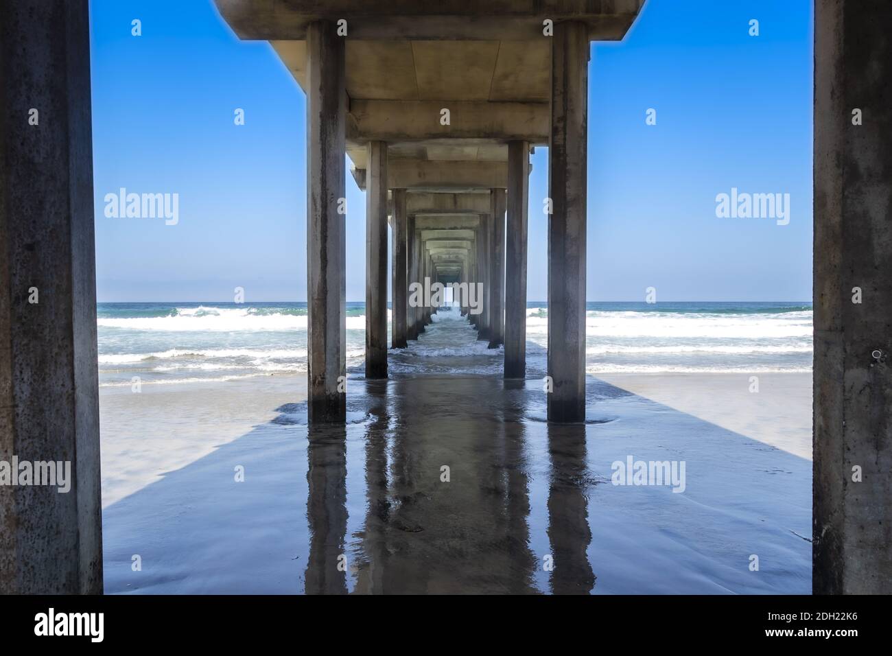 Blick auf EINEN Pier mit Wellen, die in die Struktur einstürzen Stockfoto