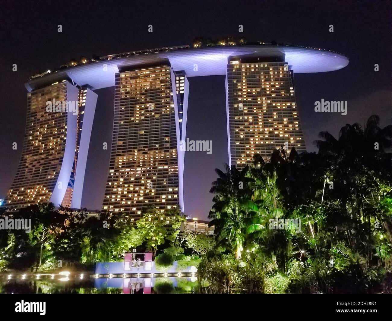 SINGAPUR - 6. Mai 2017: Blick bei Nacht auf das Marina Bay Sands Luxushotel, Einkaufszentrum und Casino, von den angrenzenden Gärten an der Bucht. Stockfoto
