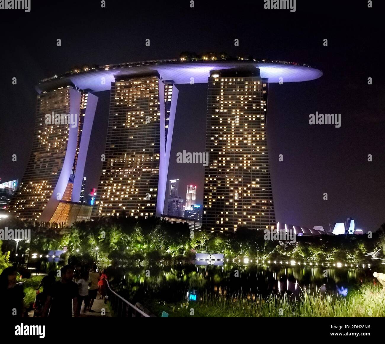SINGAPUR - 6. Mai 2017: Blick bei Nacht auf das Marina Bay Sands Luxushotel, Einkaufszentrum und Casino, von den angrenzenden Gärten an der Bucht. Stockfoto