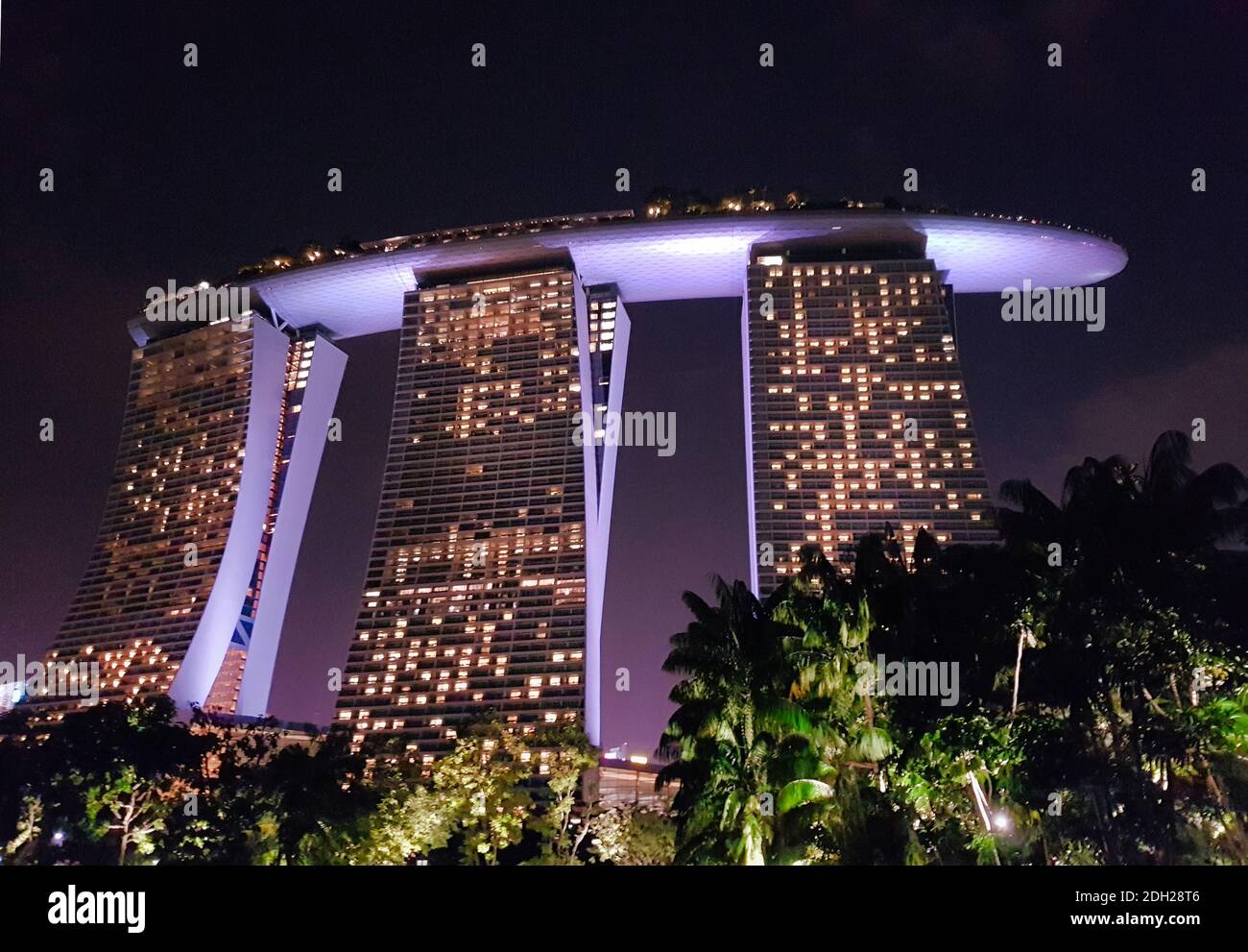 SINGAPUR - 6. Mai 2017: Blick bei Nacht auf das Marina Bay Sands Luxushotel, Einkaufszentrum und Casino, von den angrenzenden Gärten an der Bucht. Stockfoto
