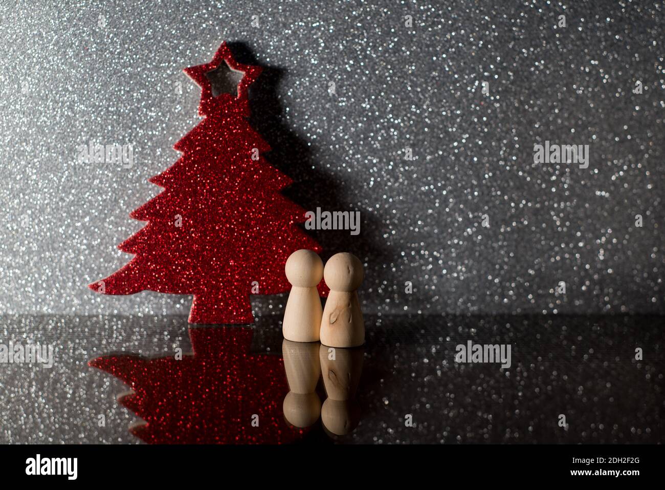 Zwei Bauern vor einem roten Weihnachtsbaum. weihnachten allein. Einsamkeit an weihnachten. Darstellung von weihnachten 2020 Stockfoto