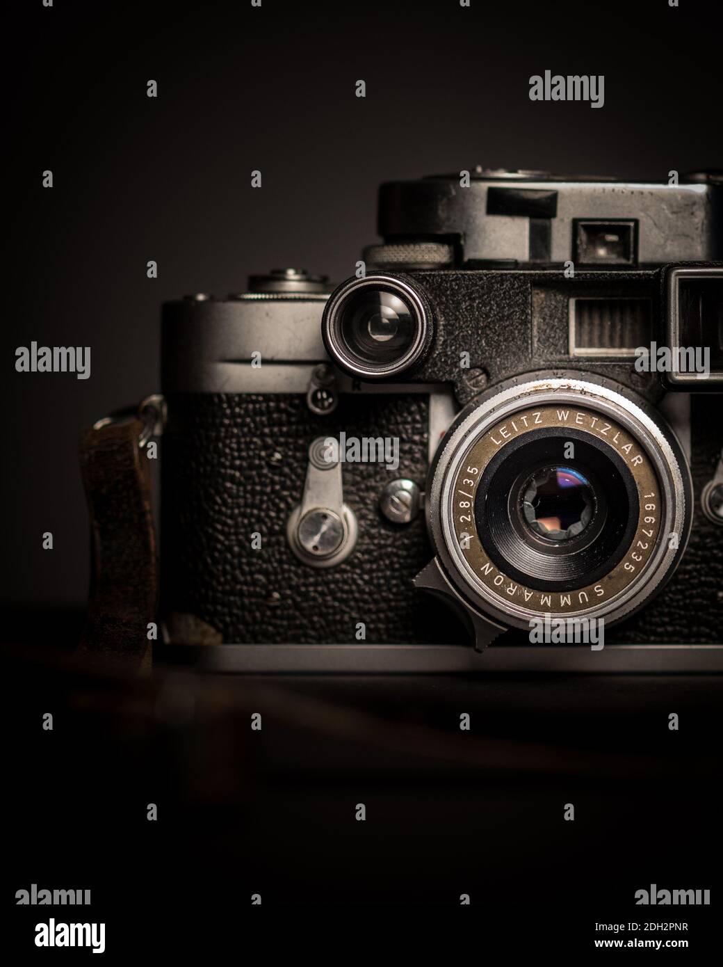 Vintage-Kamera mit Rollfilm-Nahaufnahme, die Hälfte des Kameragehäuses und Objektiv, Foto von rechts und schwarzem Hintergrund aufgenommen Stockfoto