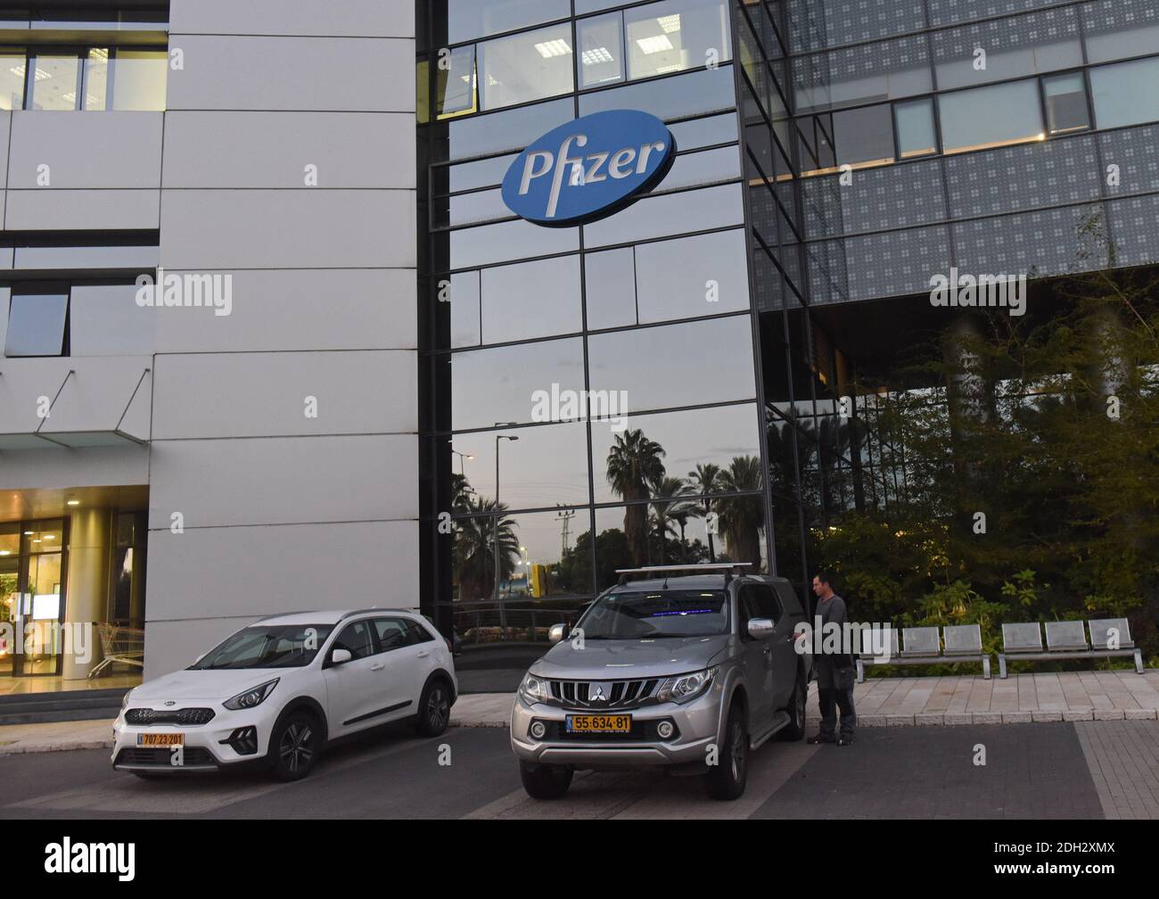 Herzliya, Israel. Dezember 2020. Unter dem Pfizer-Logo steht am Mittwoch, den 9. Dezember 2020, ein Mann vor der Zentrale von Pfizer Pharmaceuticals Israel in Herzliya, Israel. Israel hat heute aus Brüssel seine erste Charge von Pfizer-Coronavirus-Impfstoffen erhalten und wird am 20. Dezember mit der Massenimpfung beginnen, um die COVID-19-Pandemie zu kontrollieren. Foto von Debbie Hill/UPI Kredit: UPI/Alamy Live Nachrichten Stockfoto