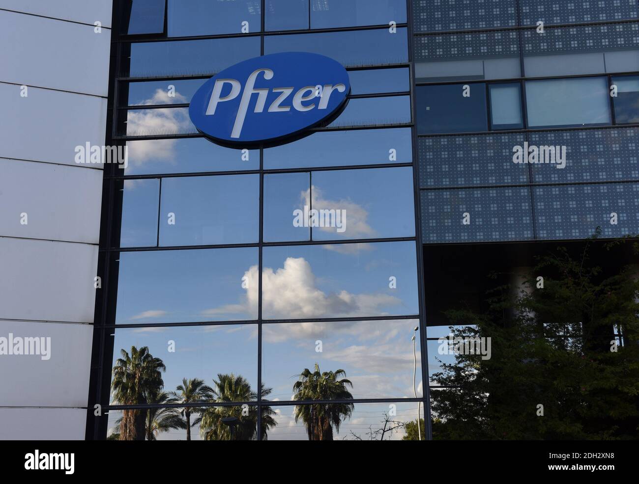 Herzliya, Israel. Dezember 2020. Palmen und Wolken spiegeln sich unter dem Pfizer-Logo am Mittwoch, den 9. Dezember 2020, außerhalb des Hauptsitzes von Pfizer Pharmaceuticals Israel in Herzliya, Israel. Israel hat heute aus Brüssel seine erste Charge von Pfizer-Coronavirus-Impfstoffen erhalten und wird am 20. Dezember mit der Massenimpfung beginnen, um die COVID-19-Pandemie zu kontrollieren. Foto von Debbie Hill/UPI Kredit: UPI/Alamy Live Nachrichten Stockfoto