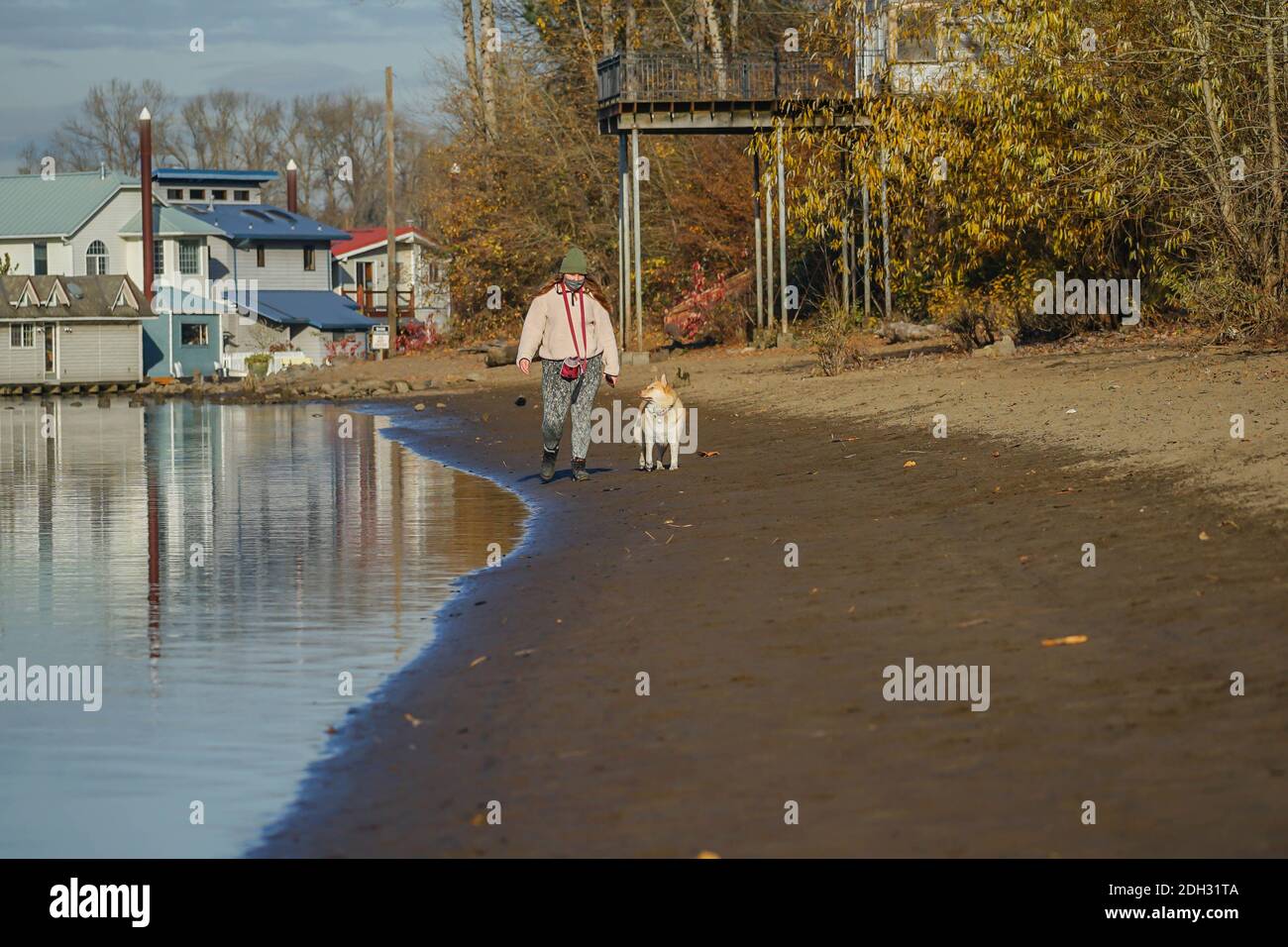Eine Frau geht mit ihrem Hund an der Flussfront des Willamette River, Oregon Stockfoto
