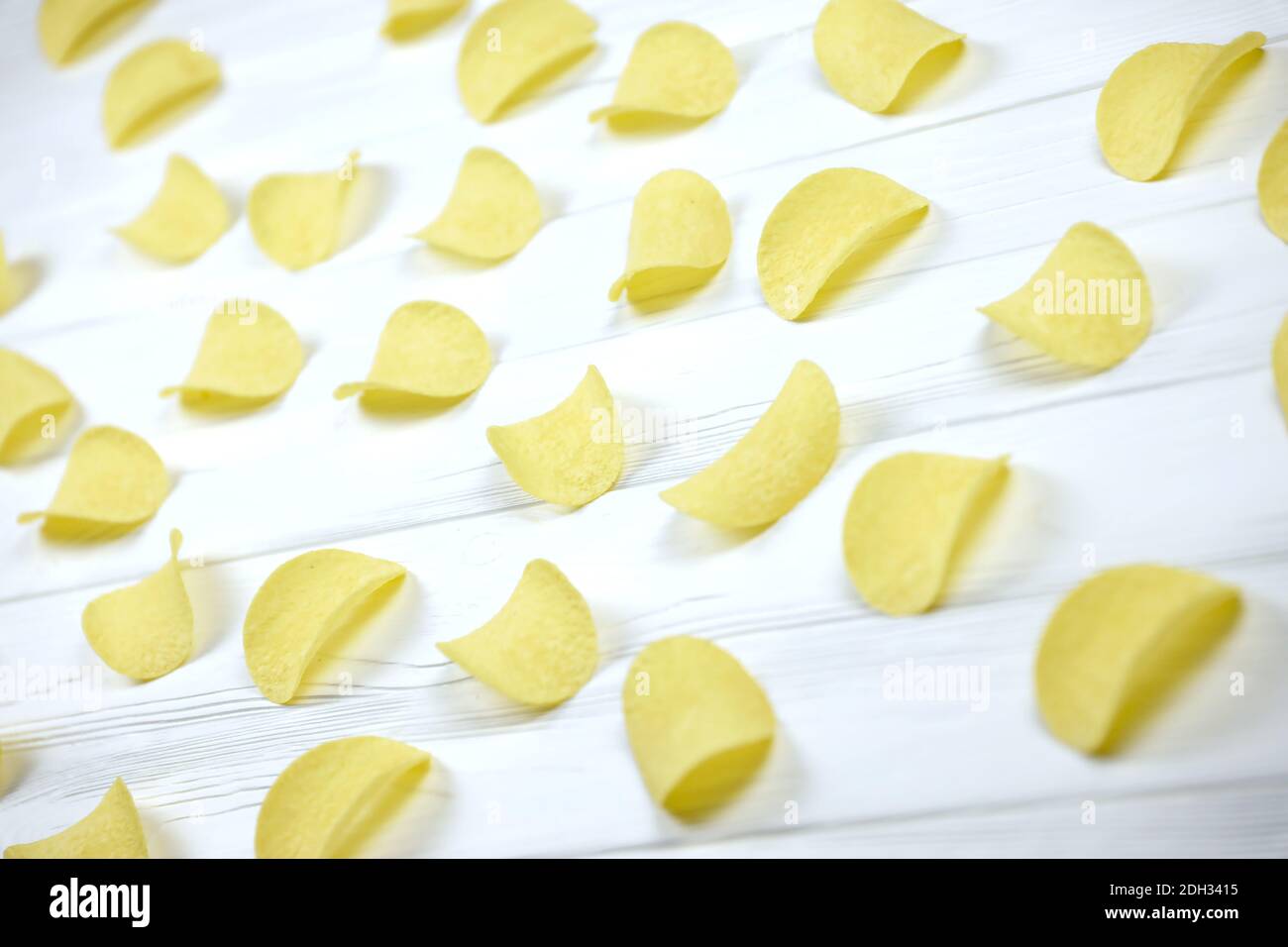 CHARKOW, UKRAINE - 23. NOVEMBER 2020: Viele orange Pringles Kartoffelchips auf weißem Holztisch. Pringles ist eine Marke von Kartoffel-Snack-Chips im Besitz b Stockfoto