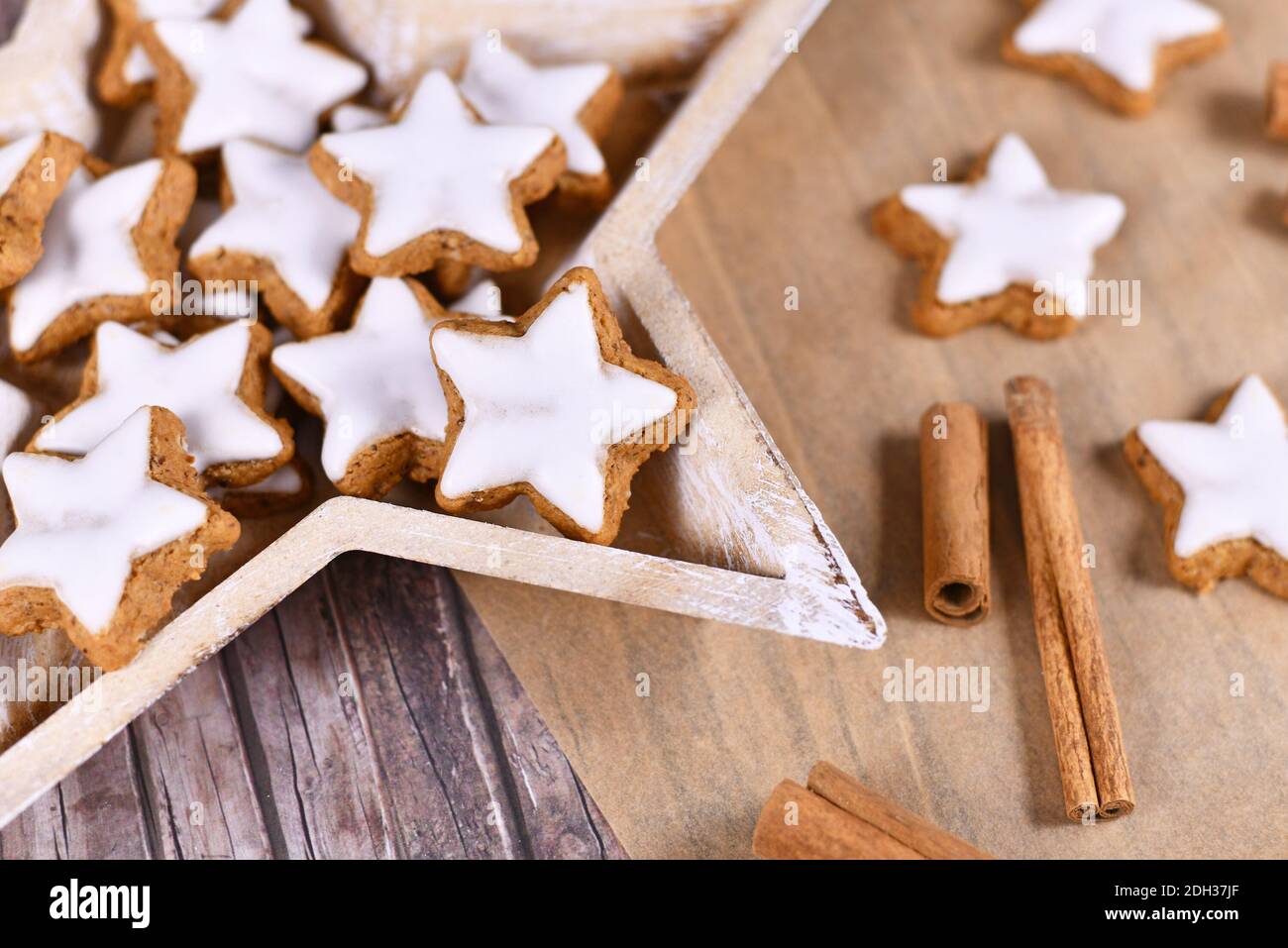 Deutsche sternförmige glasierte Weihnachts-Zimtsterne-Kekse, hergestellt aus Amondinen, Eiweiß, Zucker, Zimt und Mehl in sternförmiger Holzform Stockfoto