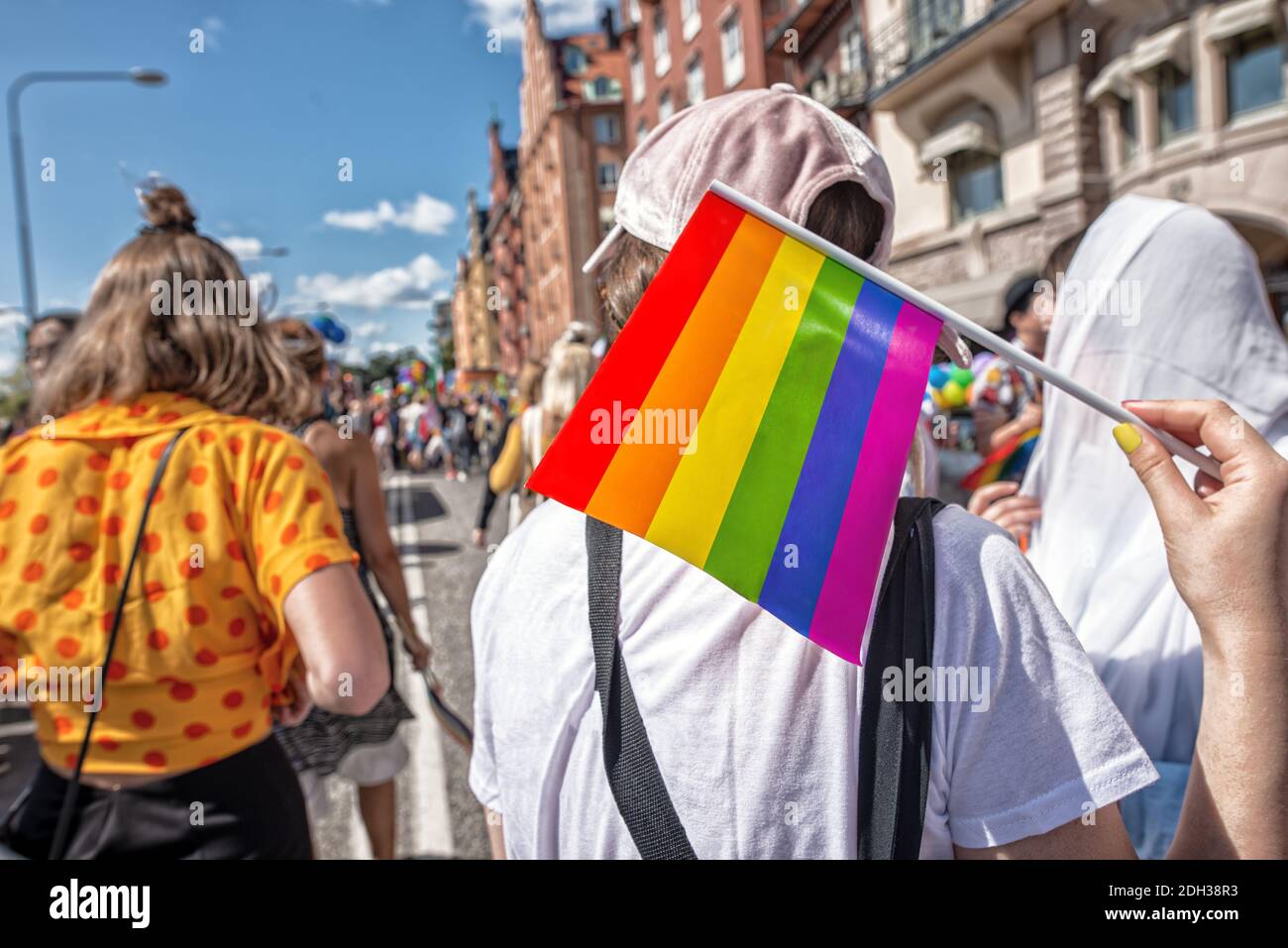 Pride Flagge in menschlicher Hand auf einer Pride Parade Stockfoto