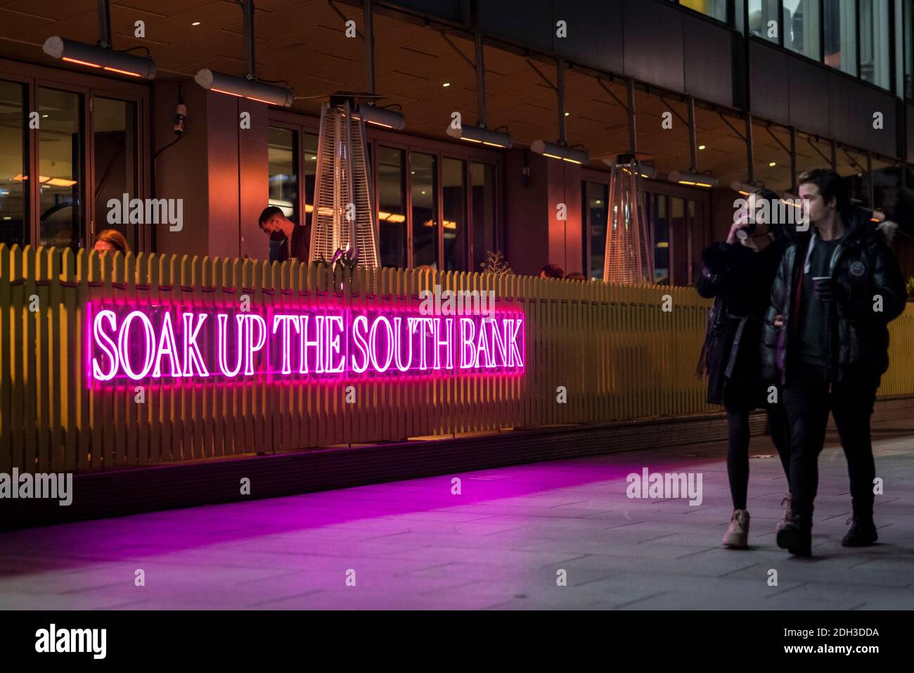 London, Großbritannien. Dezember 2020. Ein Neonschild vor einem Restaurant mit dem Text „Soak up the Southbank“ beleuchtet die South Bank in der Nacht. Mit der Lockerung der Sperre am 2. Dezember kann die Öffentlichkeit in der Hauptstadt Restaurants besuchen, um dort zu speisen, solange die entsprechenden Covid-19-Protokolle eingehalten werden. Kredit: Stephen Chung / Alamy Live Nachrichten Stockfoto