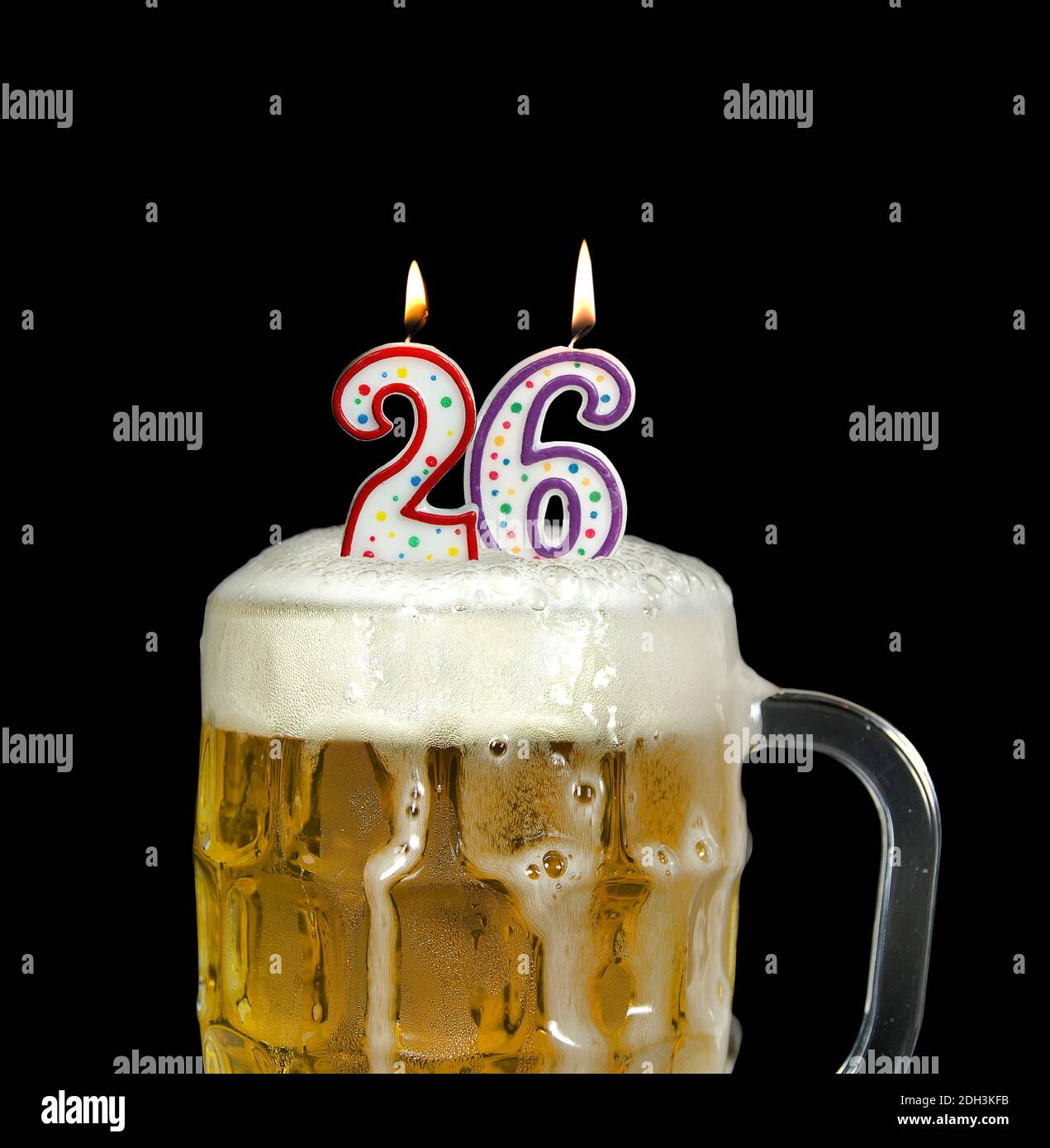 Zündete Zahlenkerzen in schaumigen Bierkrug zum 26. Geburtstag an Isoliert auf Schwarz Stockfoto