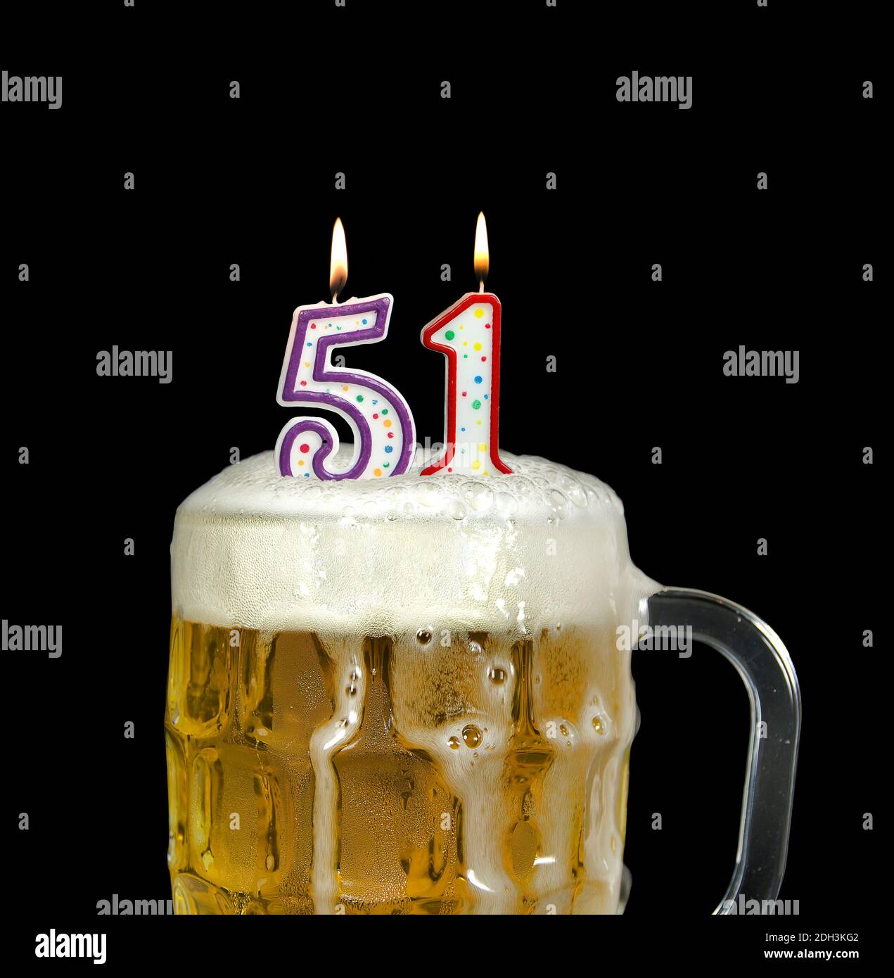 Zündete Zahlenkerzen in schaumigen Bierkrug zum 51. Geburtstag an Isoliert auf Schwarz Stockfoto