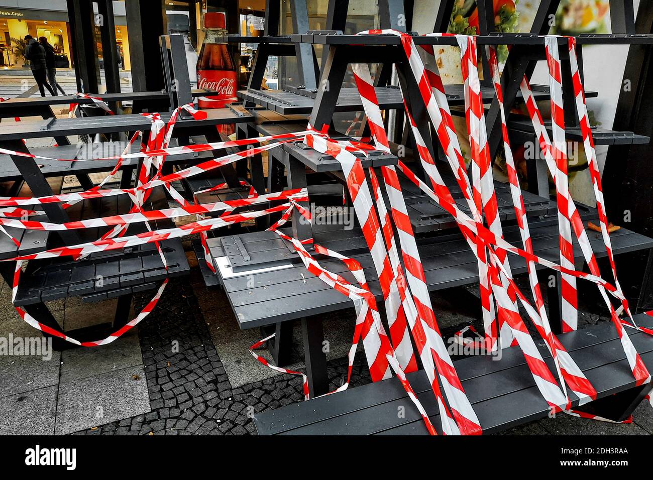 Dortmund, 09.12.2020 - im Außenbereich eines Backshops sind Tische und Bänke mit rot-weißem Flatterband abgeperrt. Restaurants und Cafés dürfen durch Corona-Regelungen nur noch Speisen zum Mitnehmen anbieten. Stockfoto
