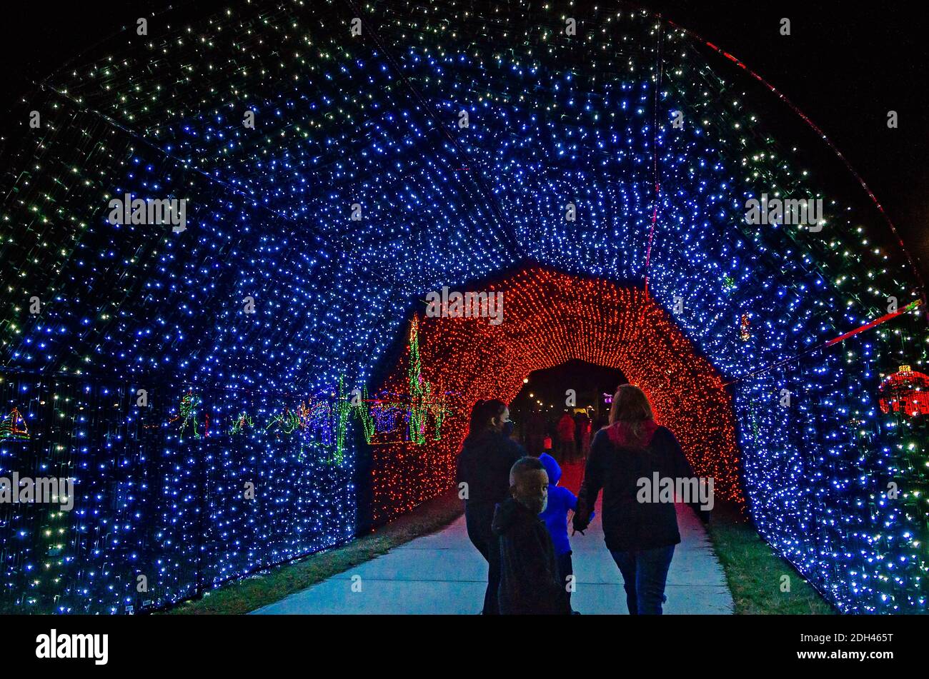 Während einer Feiertagsfeier im Jones Park am 5. Dezember 2020 in Gulfport, Mississippi, laufen die Menschen durch einen LED-Tunnel mit Weihnachtsbeleuchtung. Stockfoto