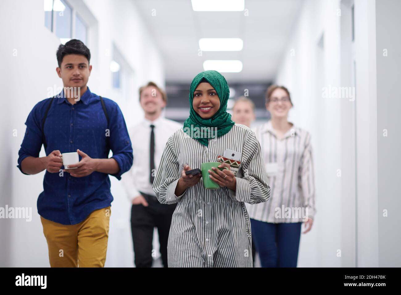 Multiethnisches Startup-Business-Team, das durch den Flur läuft Stockfoto
