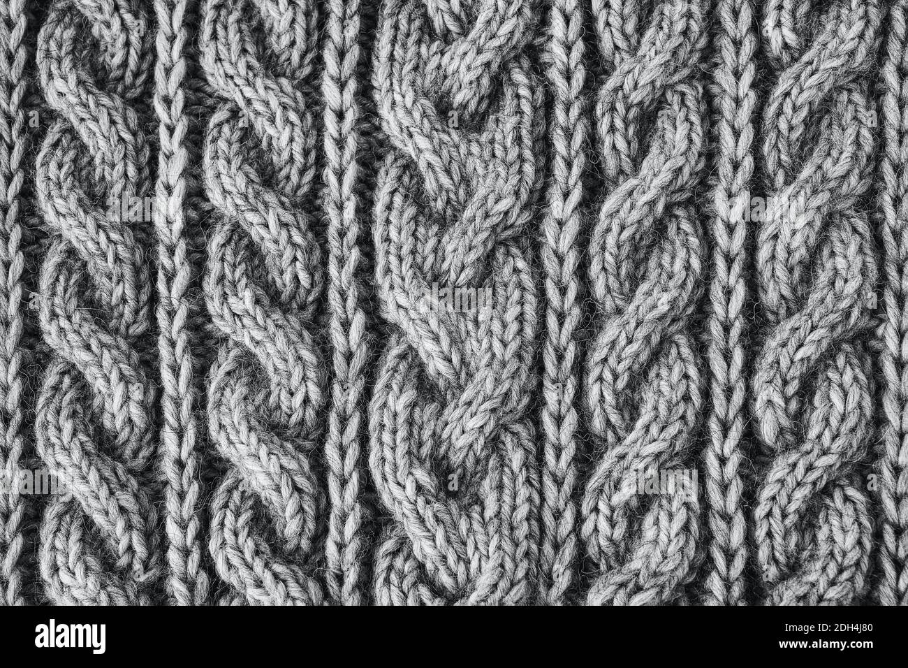 Graue Strickstruktur. Handgefertigte Strickmode. Hintergrund. Farbe von 2021. Handgefertigte Strickmode. Strukturierter Hintergrund. Stockfoto