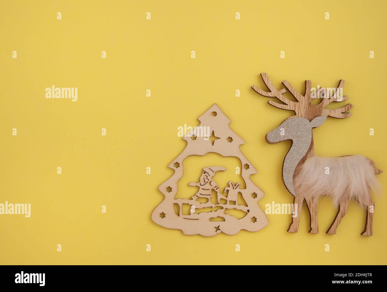 Kreative Idee im minimalistischen Stil für Weihnachten oder Neujahr Themen. Hölzerner Weihnachtsbaum und Rentier Hintergrund. Feierliches Konzept. Stockfoto