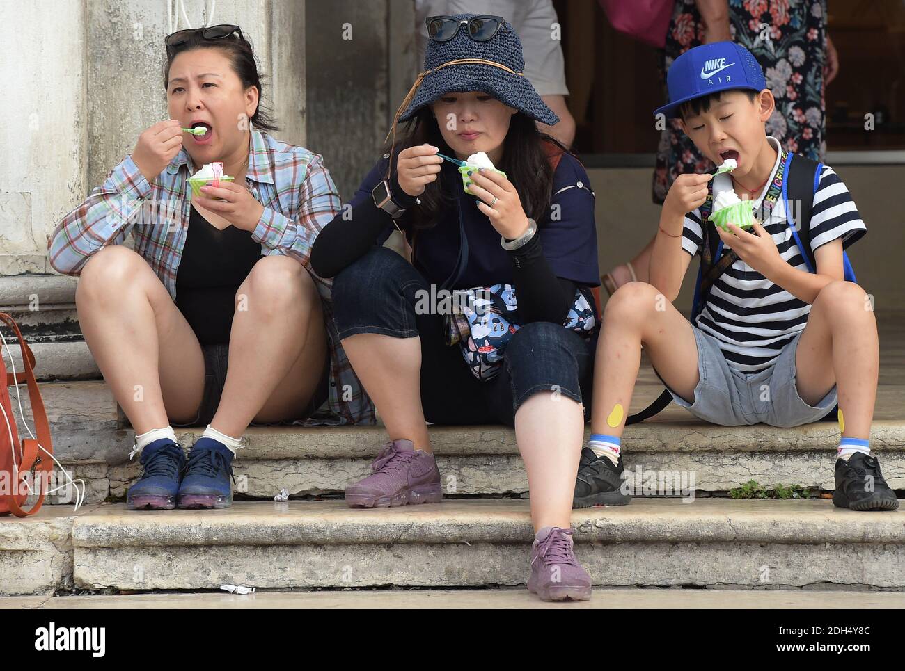 KEINE WEB/KEINE APPS - Asiatische Touristen am 12. August 2017 auf dem Markusplatz, dem Zentrum der touristischen Schwerkraft in Venedig, Italien. Hier ist es verboten zu sitzen. Die Stadt Venedig, die von Touristen überfallen wird, riskiert, ‘D„Inselland am Meer“ zu werden. Die meisten Venezianer verachten die giganten Kreuzfahrtschiffe, die jeden Tag durch den Giudecca-Kanal schaufeln, Dämpfe aussenden, die zu Erosion des Watts und Sedimentverlust führen, bevor sie Tausende von Menschen in das historische Zentrum verschleppen. Ob durch Selfie-Stöcke, laute Wheelie-Koffer oder Leute, die auf einer der 391 Brücken schnüffeln, Venedigs Verachtung gegenüber Th Stockfoto