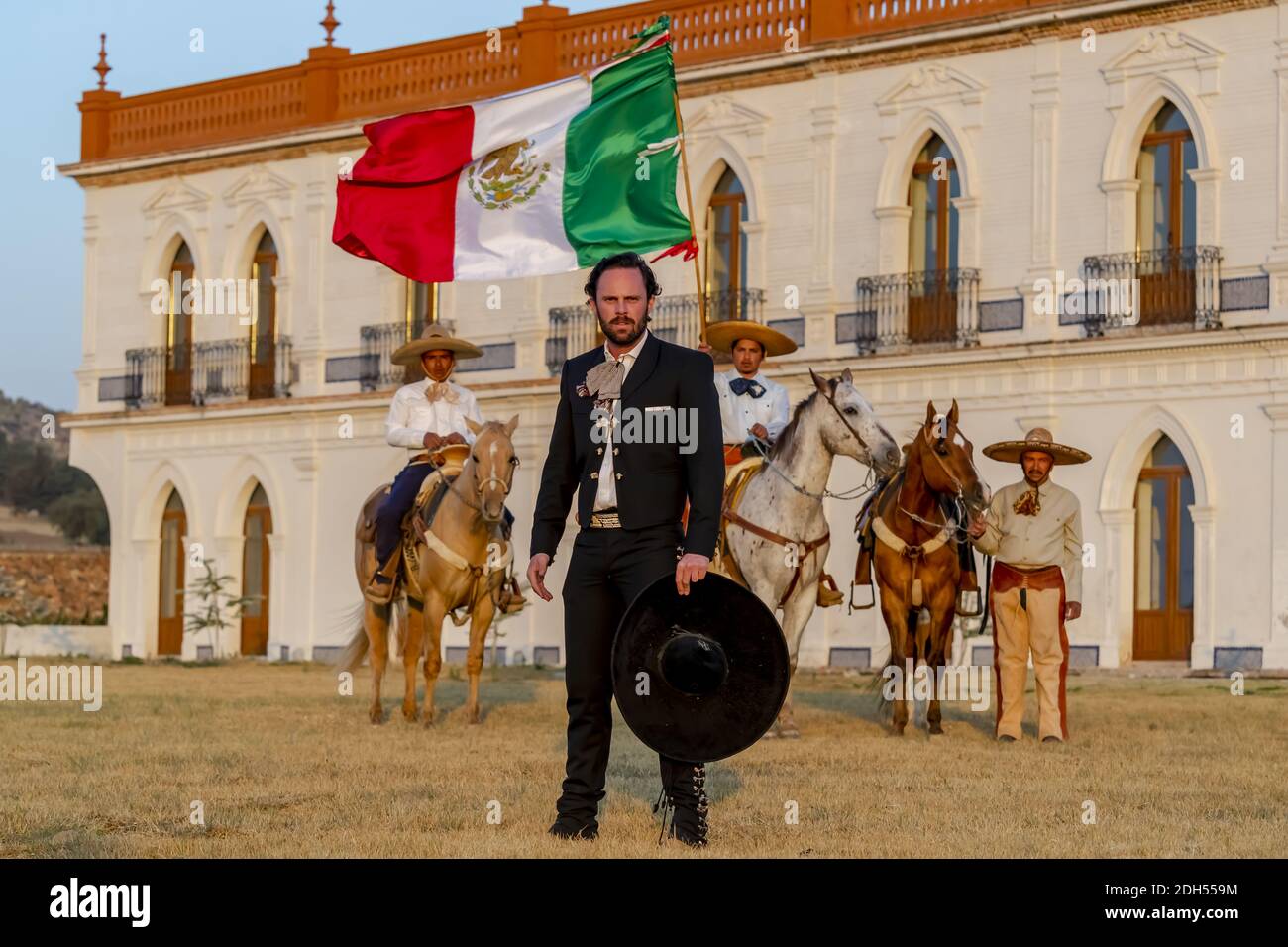Ein sehr schöner mexikanischer Charro posiert vor EINEM Hacienda In Der Mexikanischen Landschaft Stockfoto