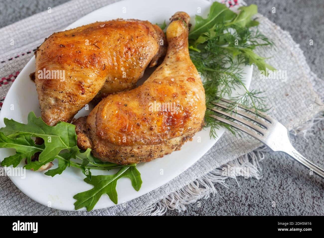 Gebackenes Hähnchenschlagstock auf einem Teller mit Kräutern. Stockfoto