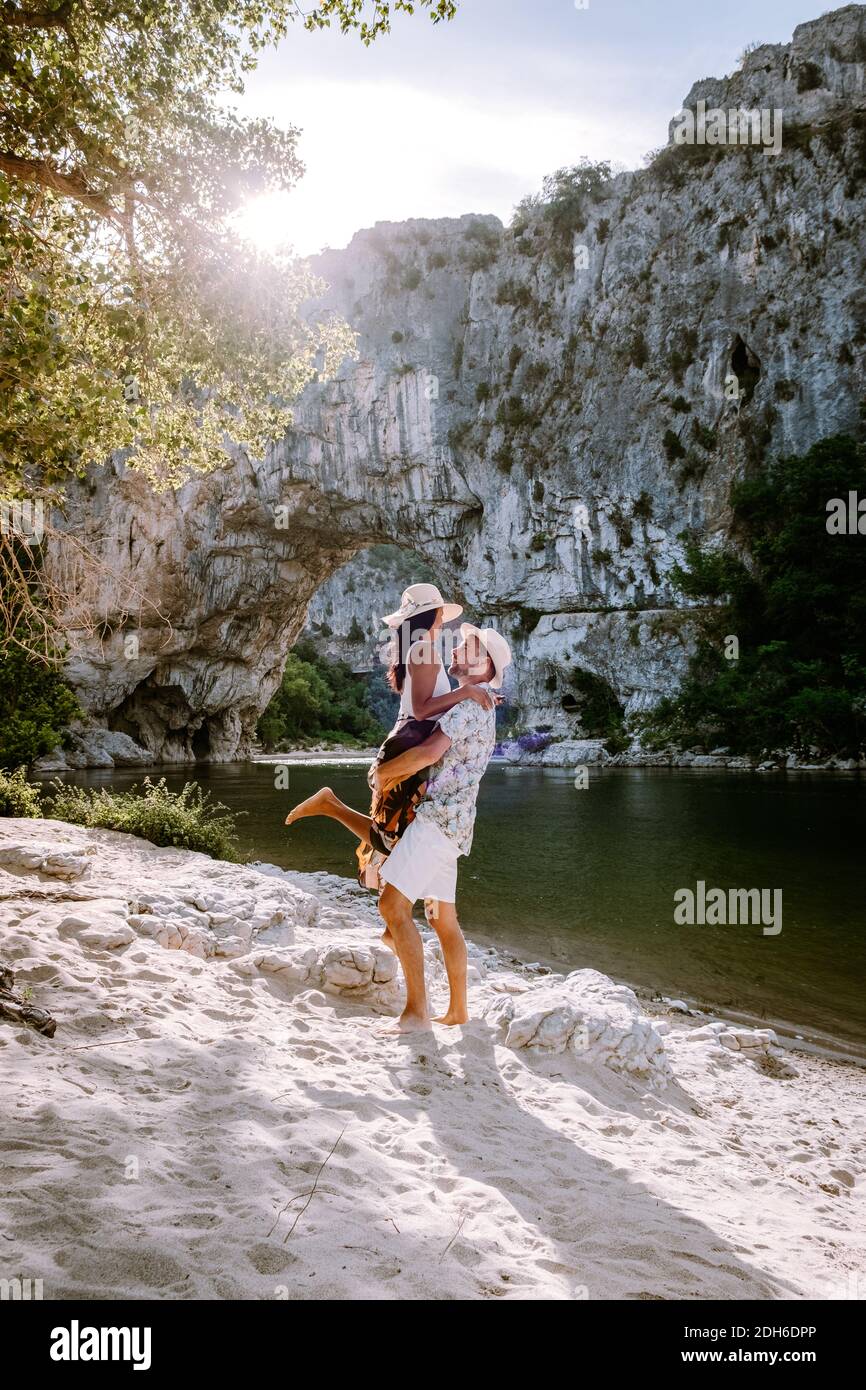Paar am Strand am Fluss in der Ardeche Frankreich Pont d Arc, Ardeche Frankreich, Blick auf den Narural Bogen in Vallon Pont d'Arc in EINEM Stockfoto