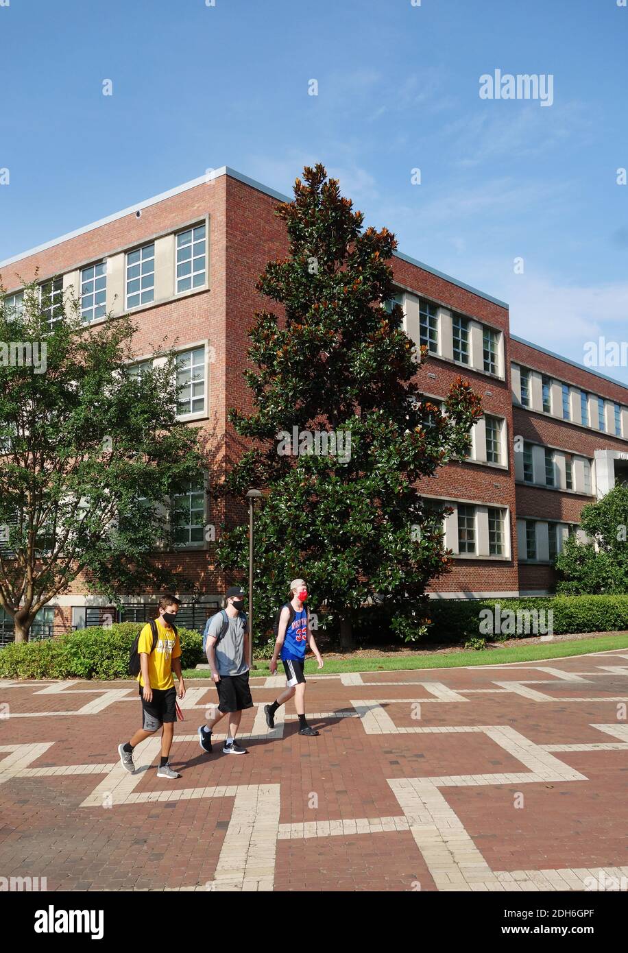 RALEIGH, NC/USA - 8-10-2020: Maskierte Studenten gehen nach der Rückkehr in den Unterricht auf dem Campus der NC State University in Raleigh, NC Stockfoto
