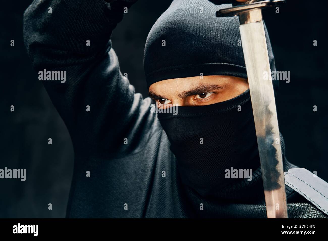 Kampf Ninja posiert mit einem Schwert über schwarzem Hintergrund Stockfoto