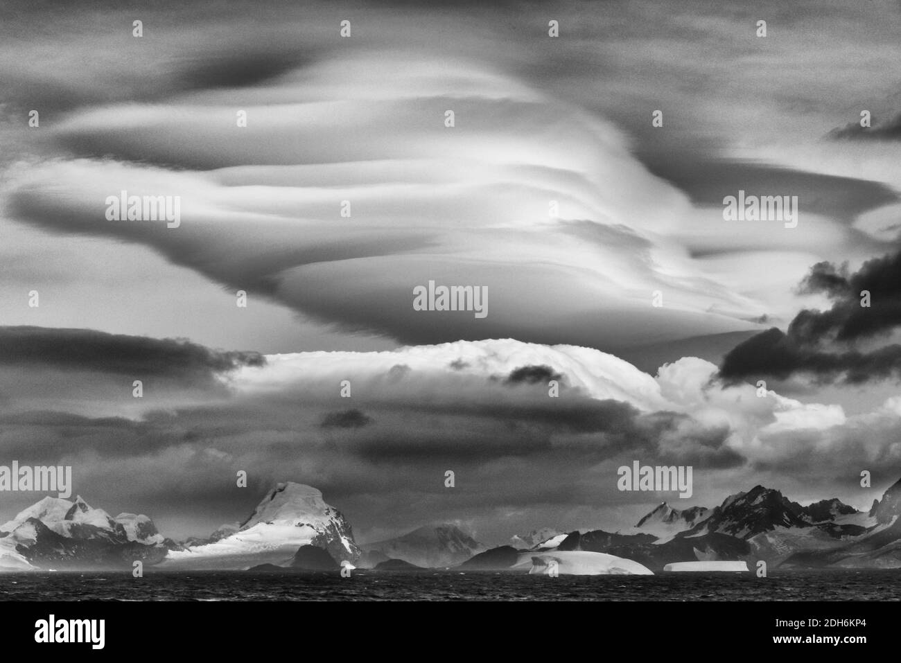 Wolkenlandschaft über den Eisbergen und Insel im Südatlantik, Antarktis Stockfoto