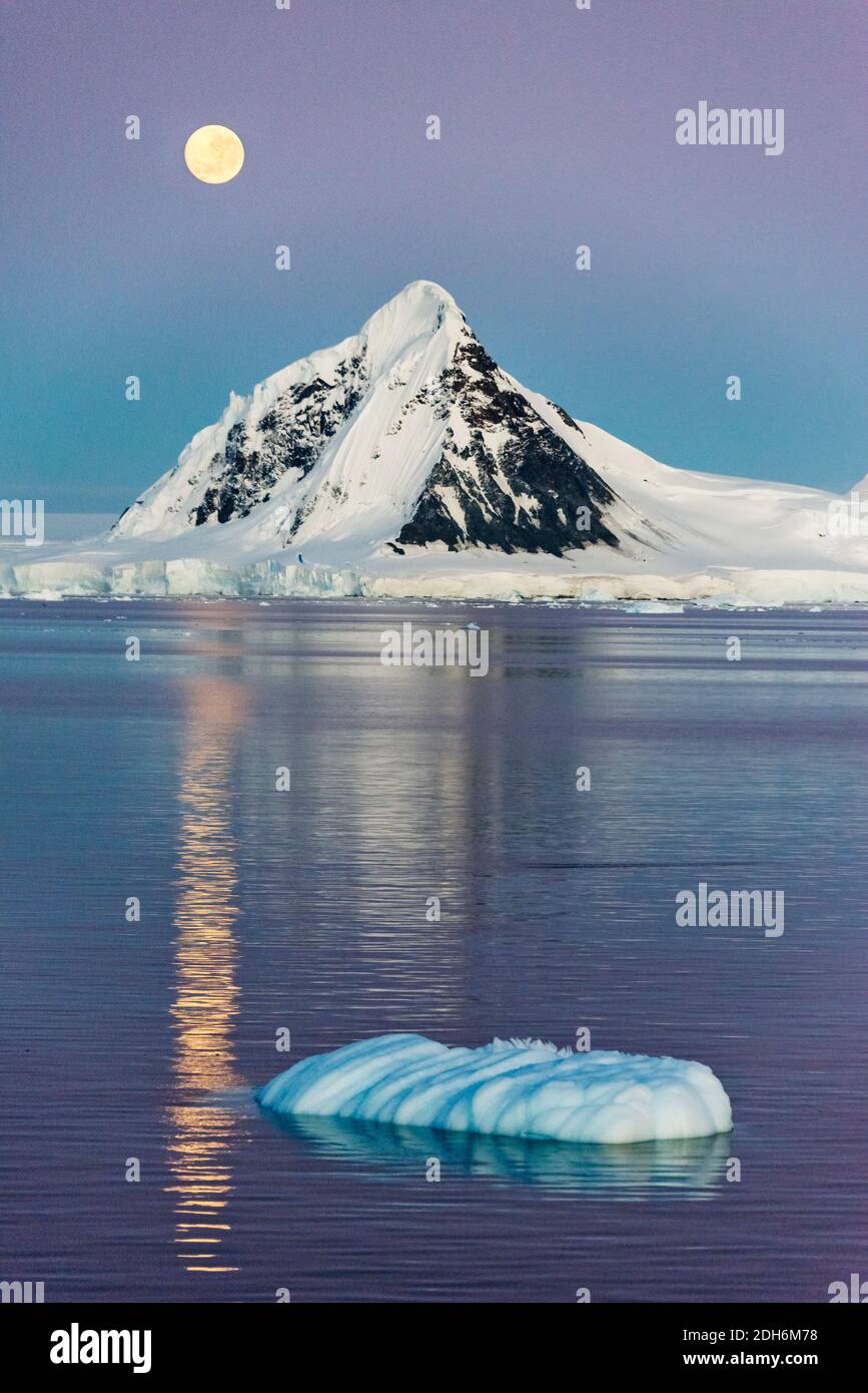 Mond über schneebedeckten Inseln und schwimmenden Eis im Südatlantik, Antarktis Stockfoto