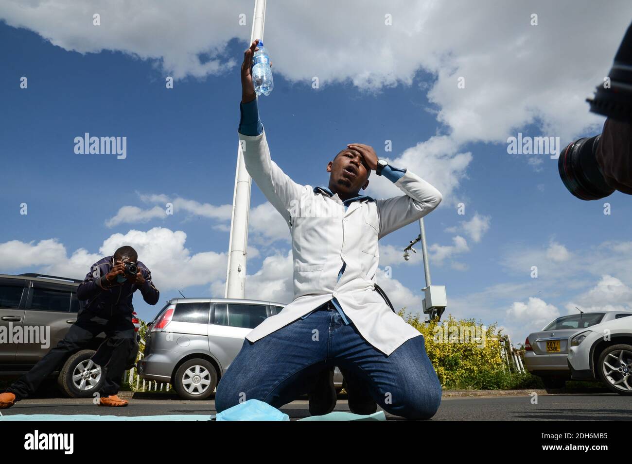 Nairobi, Kenia. Dezember 2020. Ein Protestler kniete während der Demonstration, während er Parolen sang.Gesundheitsarbeiter protestieren vor dem Hauptquartier des Gesundheitsministeriums, um einen ihrer Kollegen, Dr. Stephen Mogusu, zu ehren, einen 28-jährigen medizinischen Arbeiter, der dem Coronavirus erlag und über schlechte Arbeitsbedingungen, Mangel an PPEs (Persönliche Schutzausrüstung) Und Nichtbezahlung von Risikozulagen für ihre Kollegen, die während dieses COVID-19-Zeitraums vor Ort sind. Kredit: SOPA Images Limited/Alamy Live Nachrichten Stockfoto