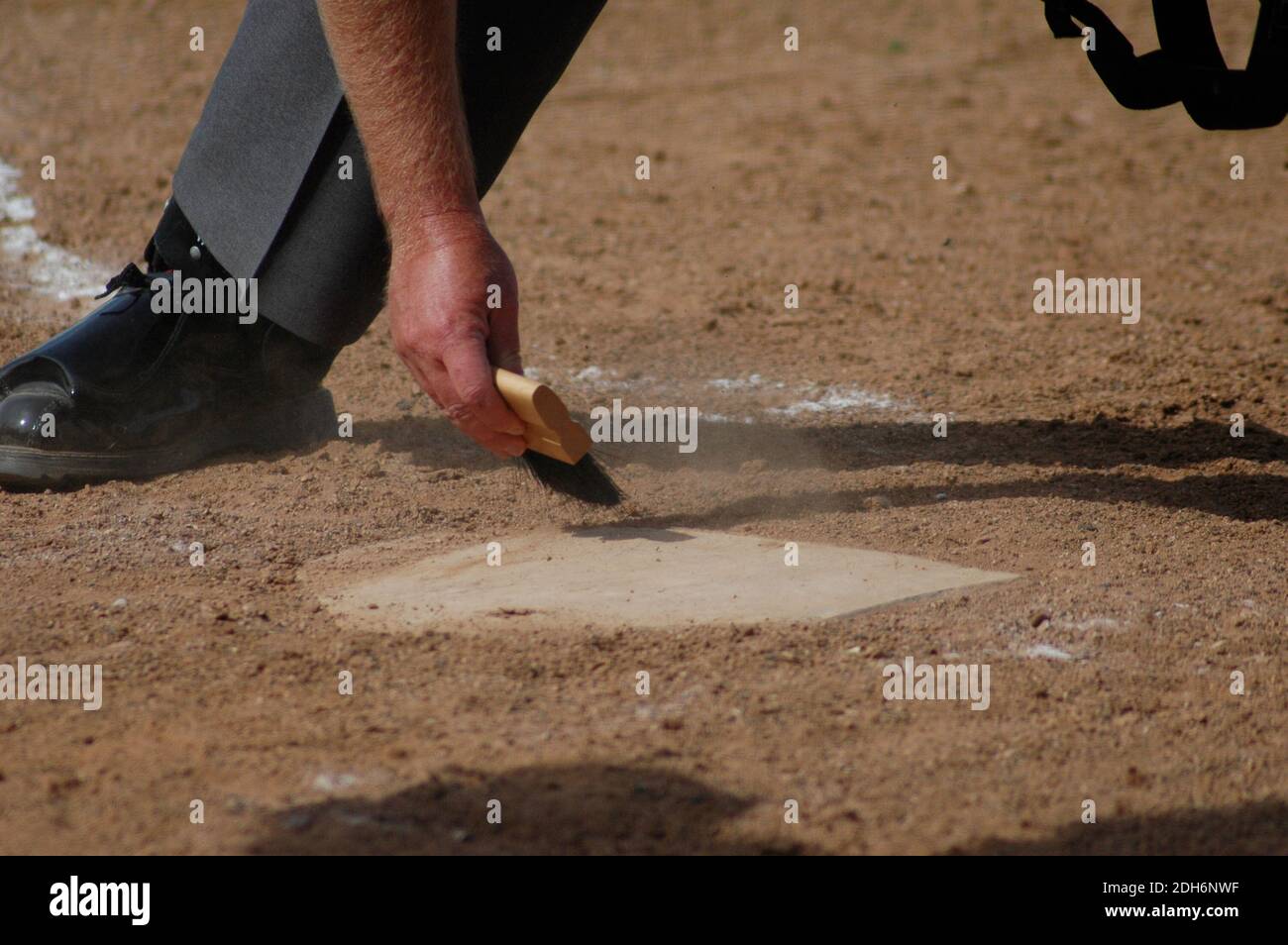 Baseball Umpire Abbürsten Home Plate Stockfoto