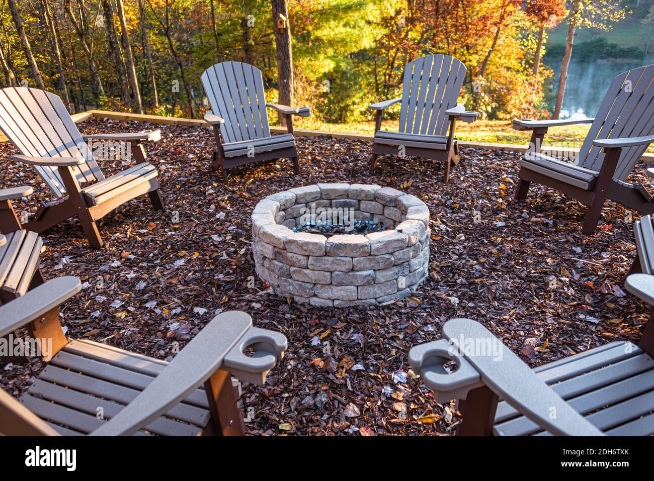 Adirondack-Stühle umkreisten eine Feuerstelle in einer luxuriösen Hütte am See an einem wunderschönen Herbsttag in den Blue Ridge Mountains von Nord-Georgia. (USA) Stockfoto