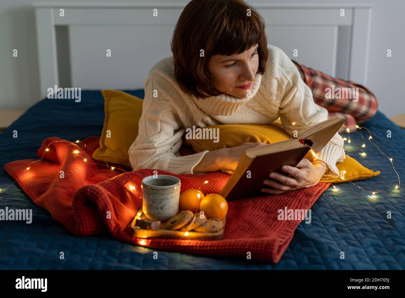 Schöne reife Frau Buch lesen. Gemütlich und erholsam. Stockfoto