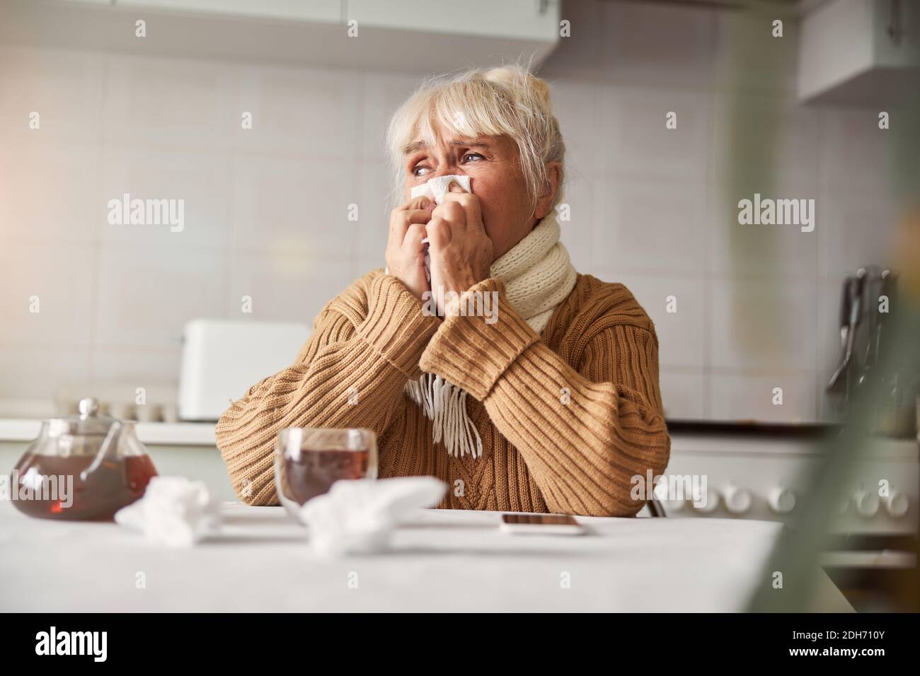 Melancholisch gealterte Dame mit einer saisonalen Erkältung und zu Hause bleiben Stockfoto