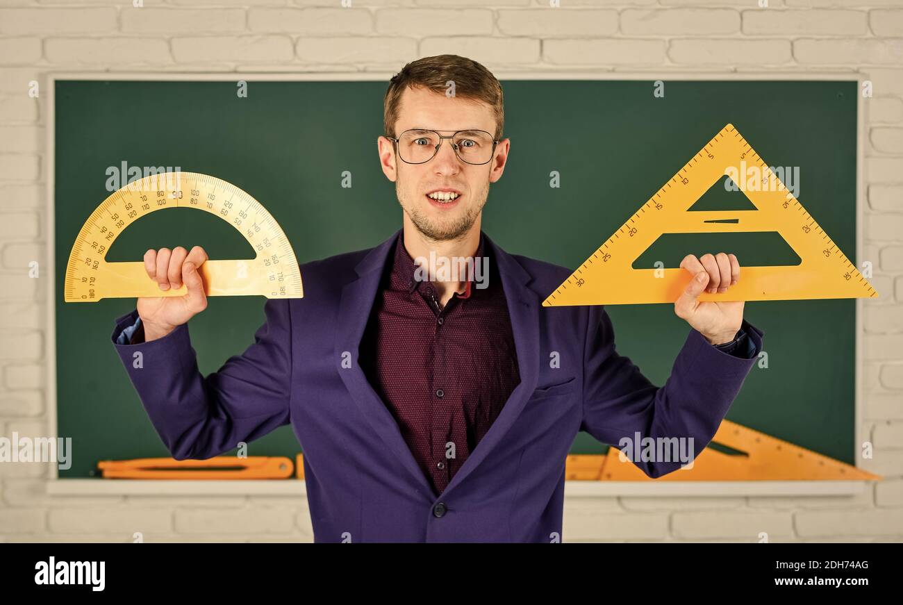 MINT Schule Disziplinen. Mathematik und Menschen Konzept. Mann an der Tafel. Zurück zur Schule. Geometrie Lieblingsthema. Männliche Lehrer halten Winkelmesser und Dreieck. Bildung in der Schule. Stockfoto