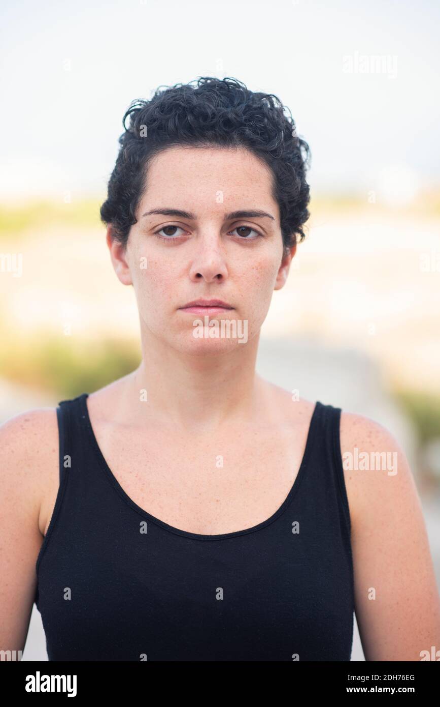 Schöne junge Frau mit kurzen Haaren Blick weg im Freien Stockfoto