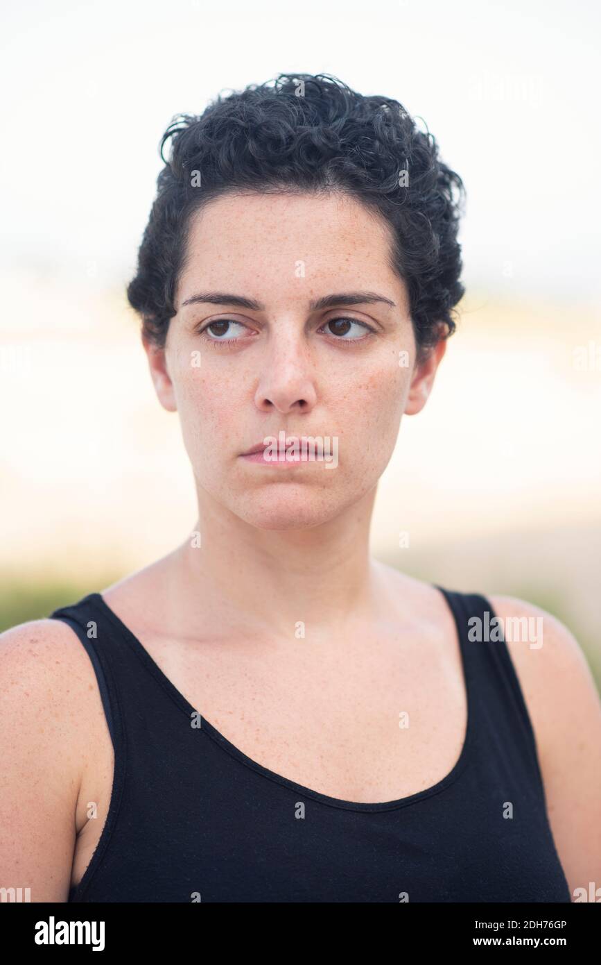 Schöne junge Frau mit kurzen Haaren Blick weg im Freien Stockfoto